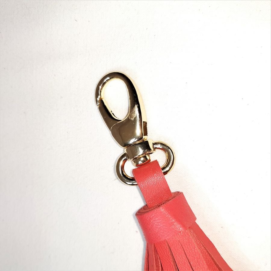 Taschenschmuck mit Pompon aus Lammleder in orangerot.