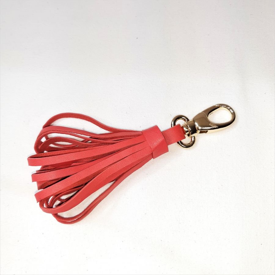 Taschenschmuck mit Pompon aus Lammleder in orangerot.